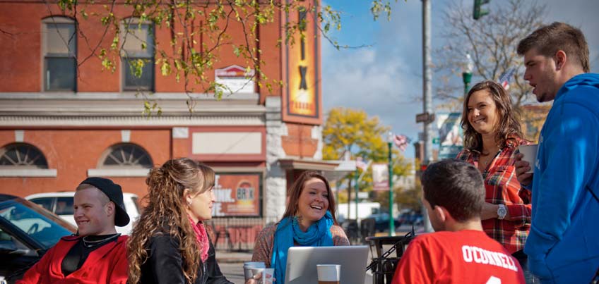 Students sit outside adjacent to Main Street Cortland