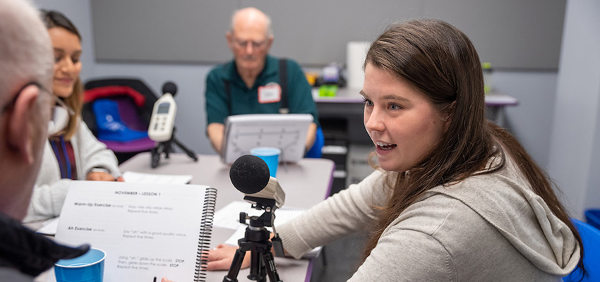 Graduate clinicians providing group therapy using the LOUD Crowd workbook and sound meter