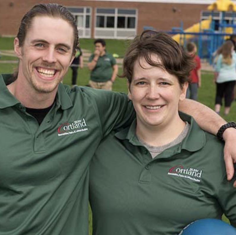 Leisure service student and instructor outside an elementary school