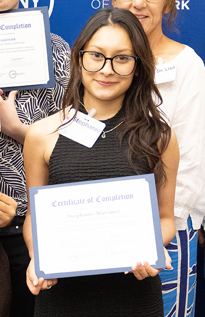 Portrait of Stephanie Martinez smiling and holding a certificate