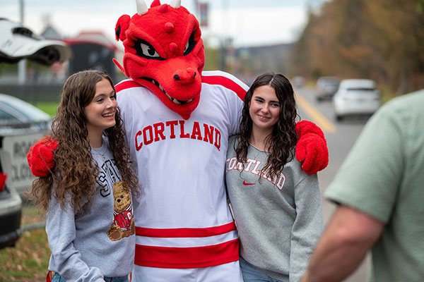 Two students with Blaze the Red Dragon mascot.