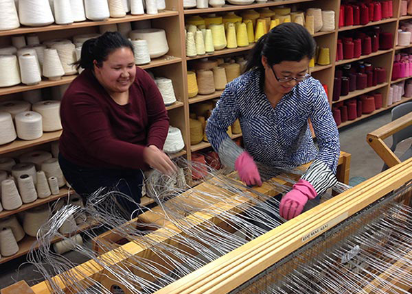 Student and professor working on a loom