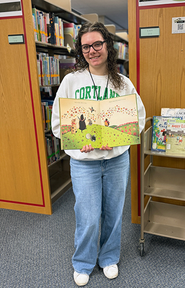 Meghan Wehner ’26 holds a book during her time as an intern at Memorial Library.