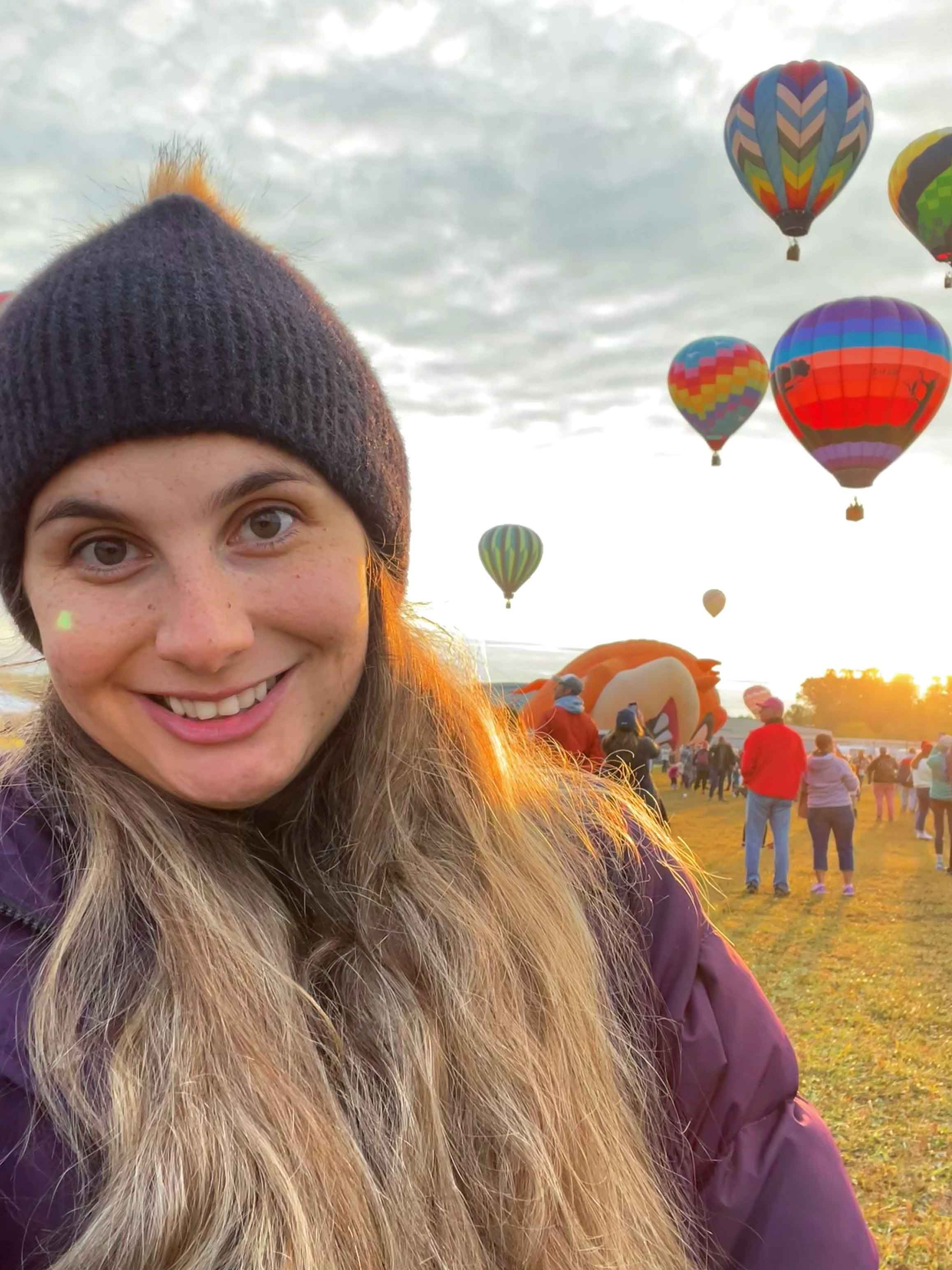 Student smiling with hot air balloons in the background