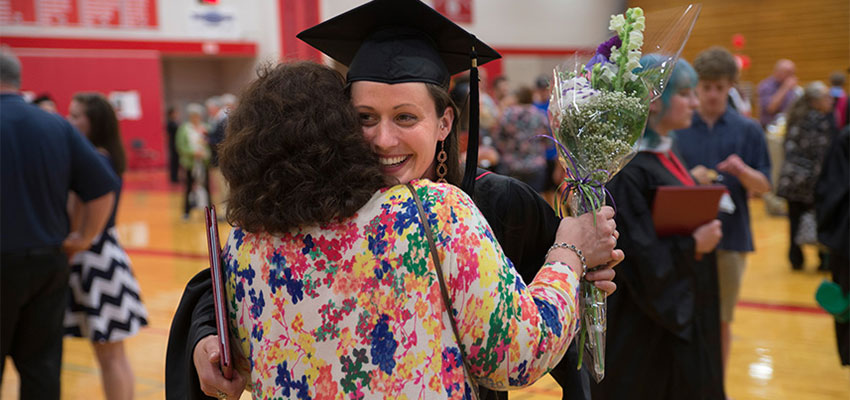Communication Sciences and Disorders graduate giving a hug at commencement