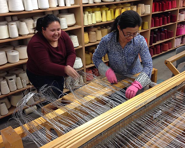 Student and professor working on a loom