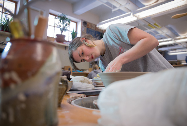 Student creating a clay bowl in the pottery stuido