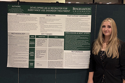 Student stands to the right of research poster on developing an AI recruiter for substance use disorder treatment