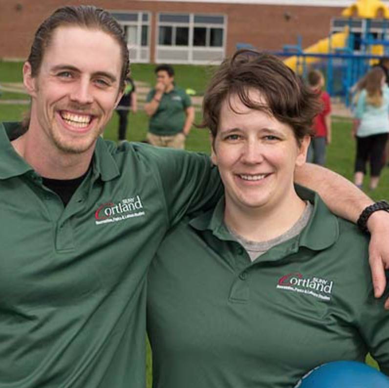 Leisure service student and instructor outside an elementary school