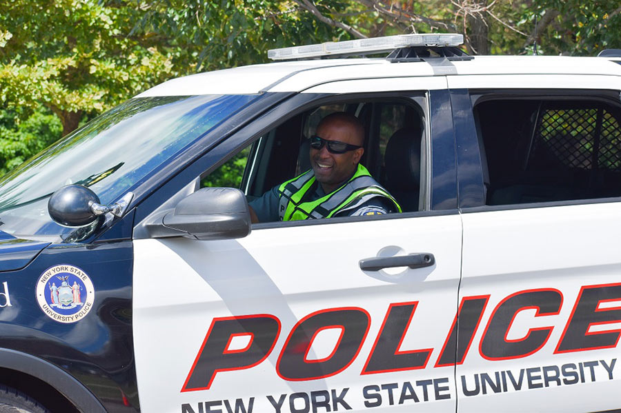 University police officer smiling in his car