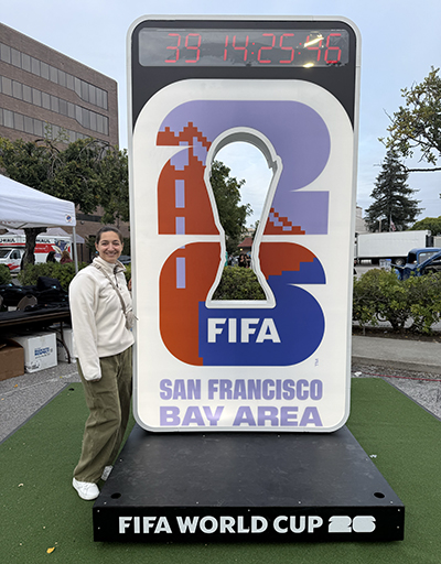 Kellie Cavalier stands next to a FIFA World Cup display in San Francisco