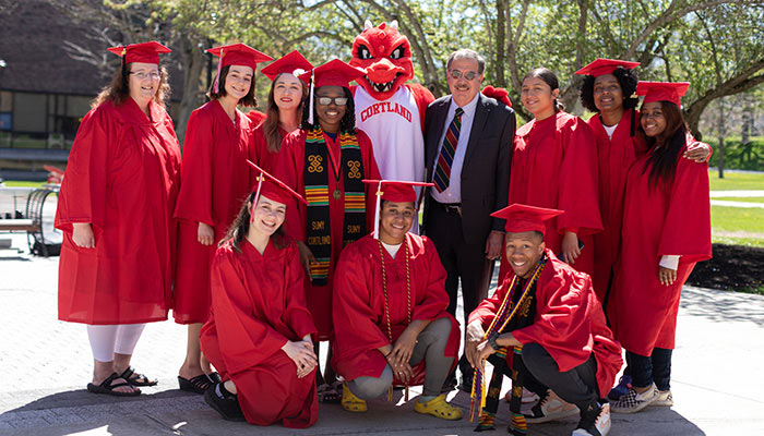Graduates pose with Blaze in their caps and gowns