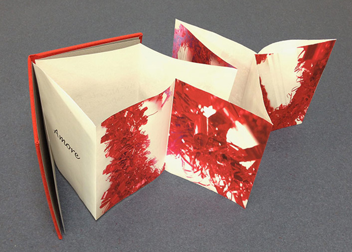 A red book with accordion pages spilling out