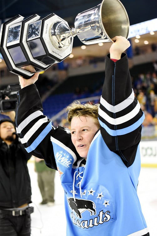 Harrison Browne on the ice holding up a championship trophy