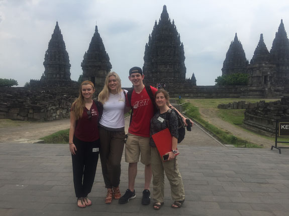 Four students posing in front of a building in Indonesia
