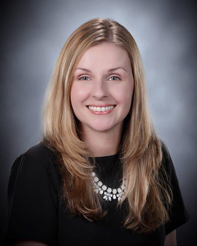 Portrait of Karen Lister smiling with a gray background