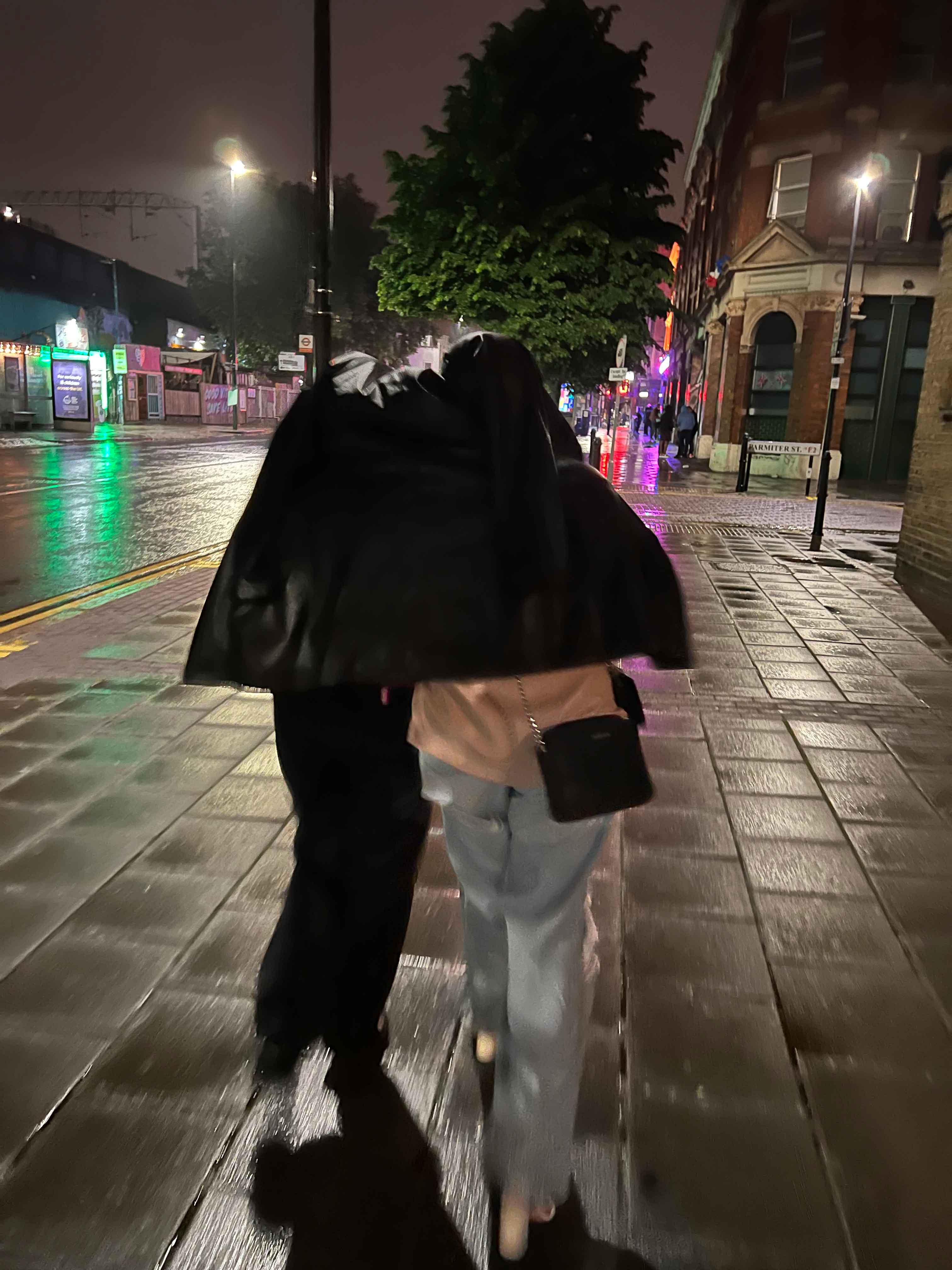 Person covering up during rain showers in London