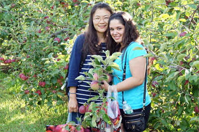 International Students and Services Page link - Two international students going apple-picking
