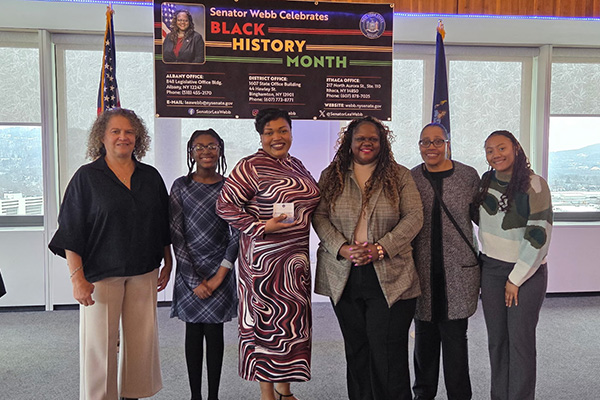 A group of six women pose for a photo as Bernice Cooper, pictured third from left, receives the New York State Senate Commendation Award from Sen. Lea Webb
