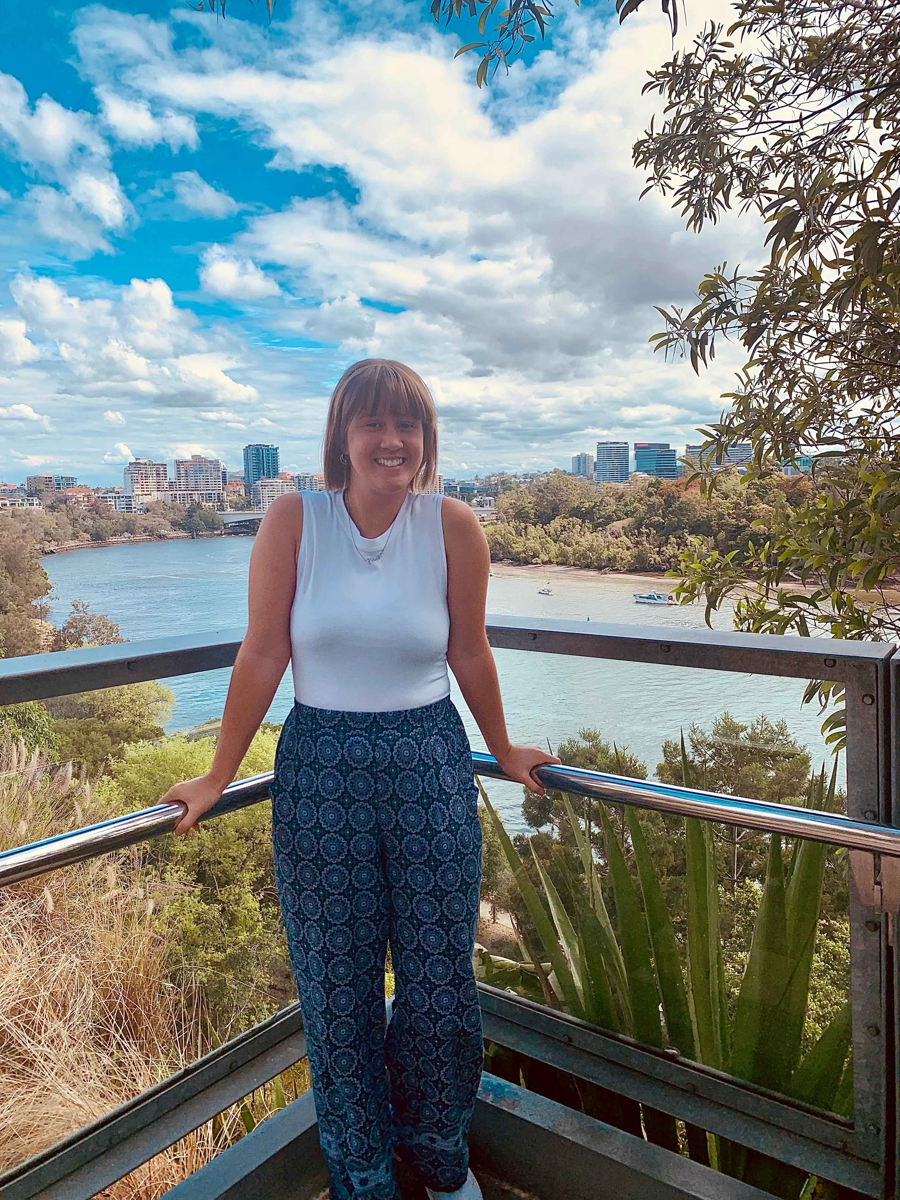 Student smiling in front of Brisbane River in Australia
