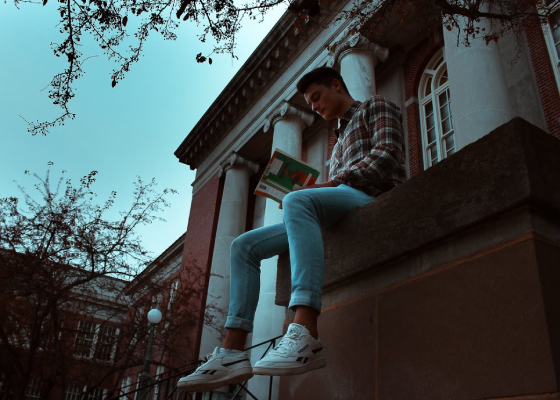 Student sitting outside of Old Main building