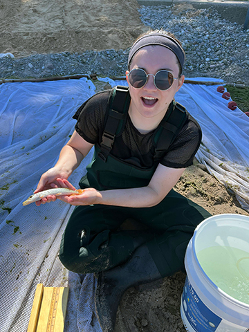 Isabella Impellizzeri holds a fish during her work with SUNY Oswego.