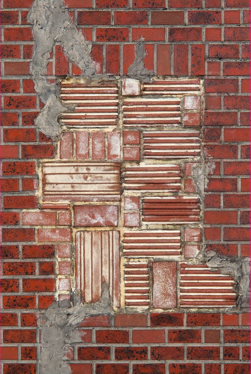 Close-up of a brick building with new brock mortared into what was previously a window