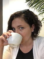 Heather Bartlett drinking a cup of coffee looking at the camera