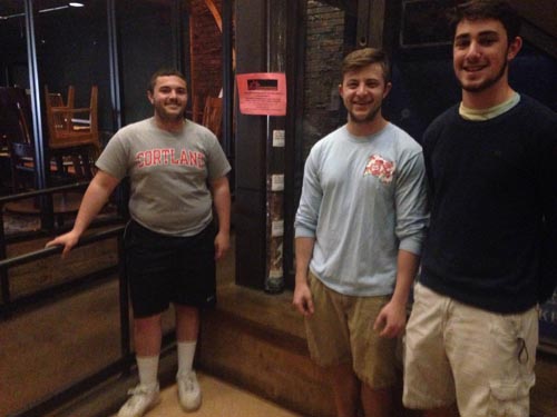 Students pose nears coin-collection cylinder in Corey Union