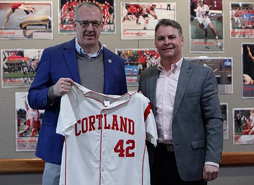 Greg Sankey receiving a baseball jersey with Mike Urtz