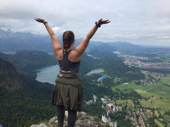 Student looking out triumphantly over the mountains in Switzerland