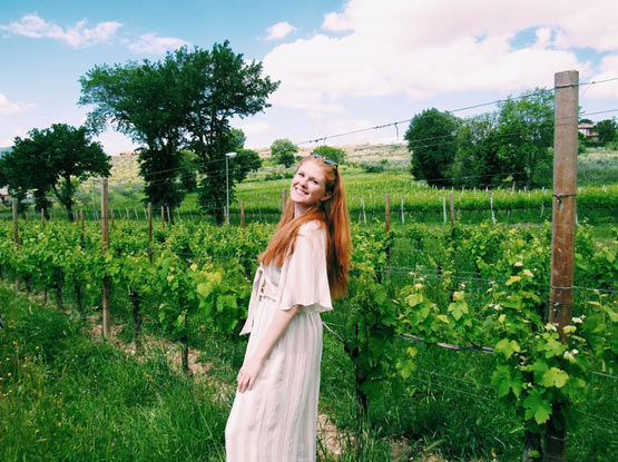 Student standing in a winery field in Montefalco, Italy