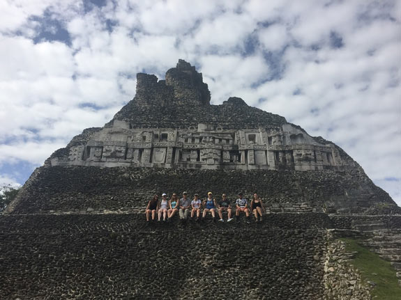 Students sitting in front of Mayan ruin of Xunantanich, Belize