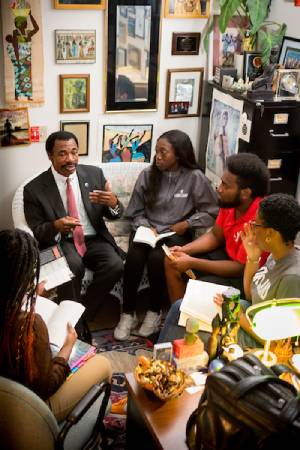 Africana Studies Department, Professor Seth N. Asumah and students talking and discussing topics in his office.