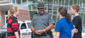 Students talking with police officer outside of Van Hoesen Hall